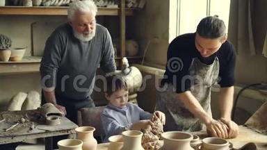 专业的陶工在家里的工作室里的工作台上捏黏土，而他的儿子正在<strong>帮助</strong>他和年迈的<strong>父亲</strong>