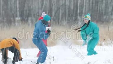 冬天。 一家人穿着五颜六色的羽绒服在森林里打雪球。 慢动作