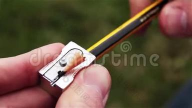 在公园里用卷笔刀削铅笔。