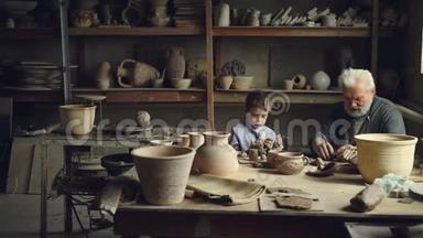 陶艺大师正在制作泥球，准备制作陶瓷图形，并将它们展示给正在玩耍的孙子