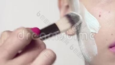 女人用刷子把奶油<strong>面膜</strong>敷在脸颊上，用于健康皮肤的化妆品、<strong>护肤</strong>、美容程序
