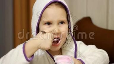 小孩用勺子吃奶酪。 小女孩吃乳制品酸奶。 肖像特写