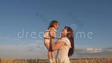 妈妈和小宝宝在熟麦地玩耍. 幸福的家庭旅行。 妈妈把一个快乐的女儿抛在天空
