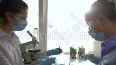 实验室助理团队在工作时间在明亮的光线下用手中的试剂做化学实验
