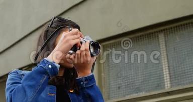 女人用数码相机在街头拍照