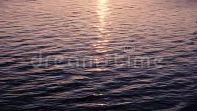 阳光在水中闪烁，粉红色的夕阳在波浪中反射