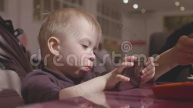 可爱的小男孩坐在咖啡馆里，和父母通<strong>电话</strong>看<strong>动画</strong>片。