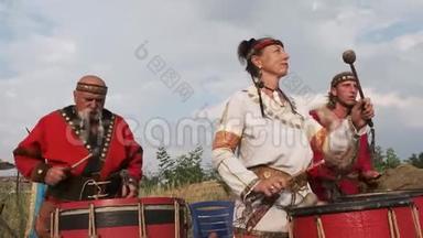 两个穿着民族服装的男人和女人在鼓声中欢快地敲打着节奏