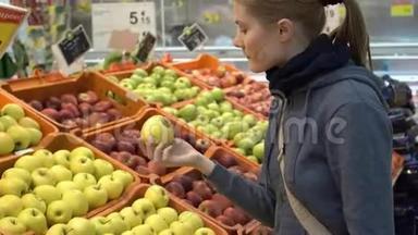 美丽迷人的年轻女人在<strong>超市</strong>里摘苹果<strong>水果</strong>。 健康的饮食观念。