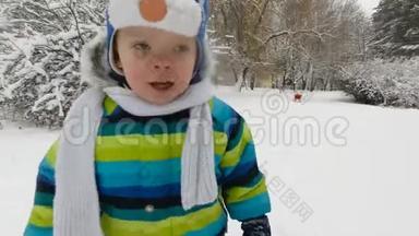 快乐的小男孩在冬天在公园里跑步。 快乐的男孩在雪地冬季公园玩得很开心。 微笑。 软焦
