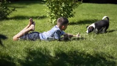 这个男孩正在草地上的公园里和一只小狗玩，白天<strong>天气晴朗</strong>，心情很好。 慢慢慢慢