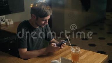帅哥，时尚男士，通过语音识别留言，在咖啡馆的智能手机上喝鸡尾酒