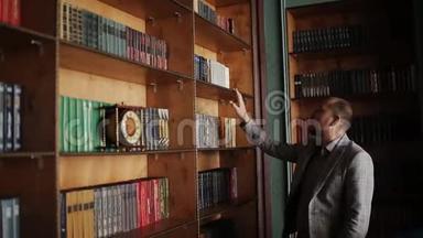 白人教授走在图书馆橱柜里看书架的肖像。