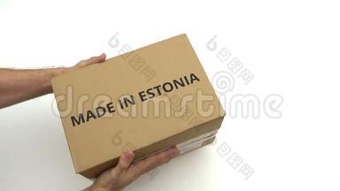 男人把纸箱和印在爱沙尼亚文字上的纸箱