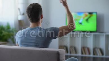 在家看<strong>大屏幕</strong>足球赛的男人为他最喜欢的球队欢呼