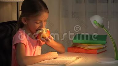 晚上在台灯读书，学习，女孩吃苹果读书