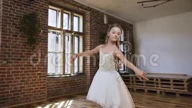 年轻的苗条芭蕾舞演员穿着白色的芭蕾舞裙，优雅地穿着尖角芭蕾舞鞋在舞厅里。 优雅的芭蕾舞演员