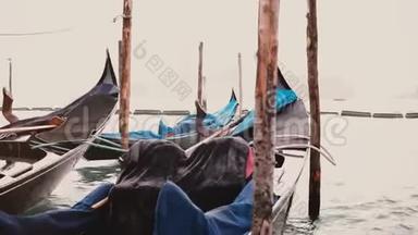 在威尼斯码头，美丽的传统贡多拉船的特写镜头，雨罩在巨浪上剧烈摇晃。
