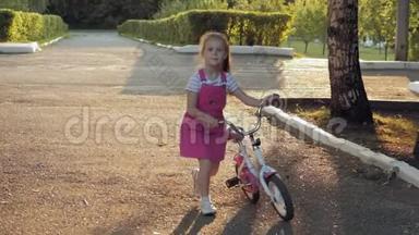 一个快乐、美丽、金发碧眼的小女孩穿着粉<strong>红色</strong>的裙子，跳投骑着一辆<strong>儿童</strong>`自行车上路