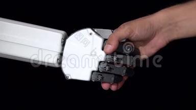 一个机器人和一个男人的<strong>手</strong>`一次握<strong>手</strong>。 黑色背景。 <strong>关门</strong>