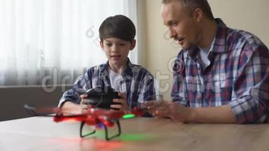兴奋的小男孩在家里经营新的无人机模型，父亲帮助他的儿子