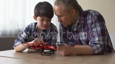 好奇的父亲和小儿子在家里检查新的四翼飞机模型，很有趣