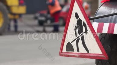 街道上的道路工程标志。 工人们把城市里的新沥青铺在路上。