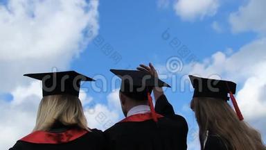 毕业生的<strong>美好未来</strong>，三个学生高举学术帽子
