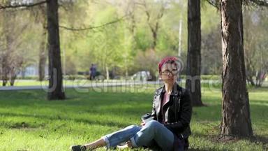 美丽年轻<strong>时尚</strong>的女人坐在公园的一棵树下，喝着一杯咖啡。 <strong>大</strong>自然中的外卖咖啡。 <strong>时尚时尚时尚</strong>