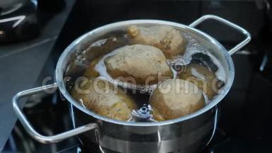 煮土豆的过程。 厨师用平底锅在炉子上煮土豆。 健康的熟食。 聪明的厨房。 蔬菜用锅煮