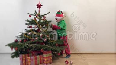有趣的<strong>小精灵</strong>在圣诞树上布置装饰品，快乐的孩子在等待圣诞节