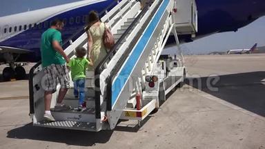 家人上飞机楼梯，父母牵着孩子的手一起度假