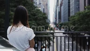 在美国纽约，年轻美丽的女人站在桥上，看着<strong>交通道路</strong>。