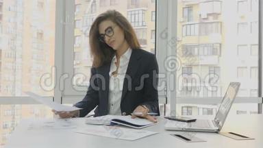 <strong>办公</strong>室工作人员，一位戴眼镜的商务女士，坐在<strong>办公楼办公</strong>室的扶手椅上工作，解决问题