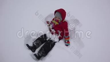 小孩子躺在雪地里，设计天使的造型，跳冬天的舞蹈