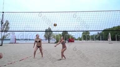 四个女人在沙滩上<strong>打排球</strong>，跳来跳去，<strong>打</strong>着球