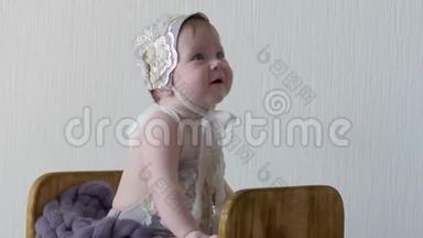 摄影，穿着帽子和衣服的婴儿坐在木箱里，对着镜头摆姿势