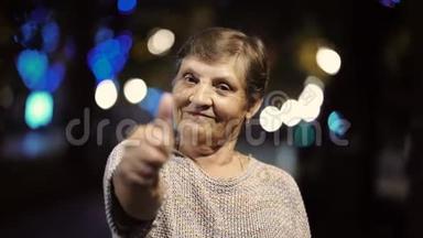 美丽的肖像，微笑的老年妇女在<strong>夜晚</strong>，灯光照亮<strong>街道</strong>。 高加索地区的祖母