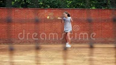在训练过程中，年轻女孩用网球火箭挡住了球