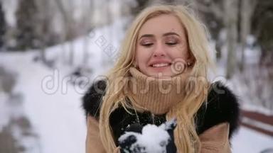 穿着黑色皮<strong>毛大衣</strong>的女孩在公园里吹雪