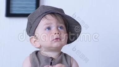时尚的孩子，戴着帽子的蓝眼睛的孩子，在家里侧着身子看着<strong>白墙</strong>