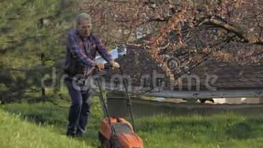 成年男子电动割草机，割草机。 园丁修剪花园