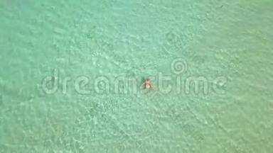 鸟瞰女人在绿松石海水。 女人在天堂海滩清澈的海水中转身