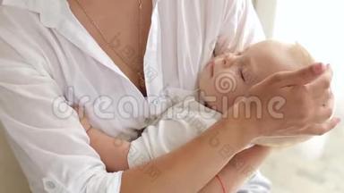 母亲把熟睡的新生婴儿抱在<strong>怀里</strong>，她坐在卧室的床上。
