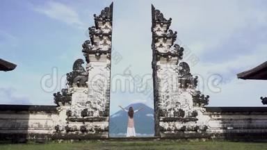 女人张开双臂，站在<strong>寺庙门口</strong>，看着阿贡火山。