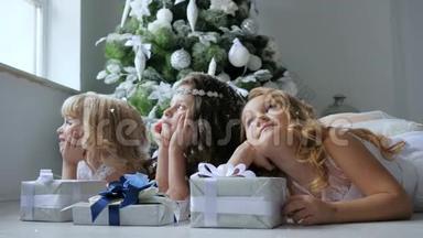 孩子们梦幻般地看着窗外的冬天，窗外装饰着圣诞树，地板上放着礼品盒