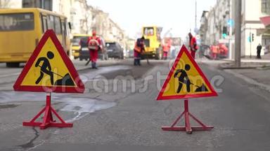 街道上的道路工程标志。 道路上的道路工程标志。 工人铺设新沥青