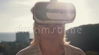 太阳落山时，一个戴着虚拟现实眼镜的女孩在房子的屋顶上。 生命生命概念