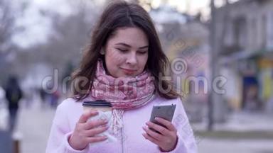 在网络交流中，女士坐在社交网络中，走路时手里拿着智能手机和一杯咖啡