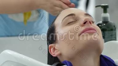 美容美发中心，理发师用专业洗发头洗美容美发中心的快乐顾客